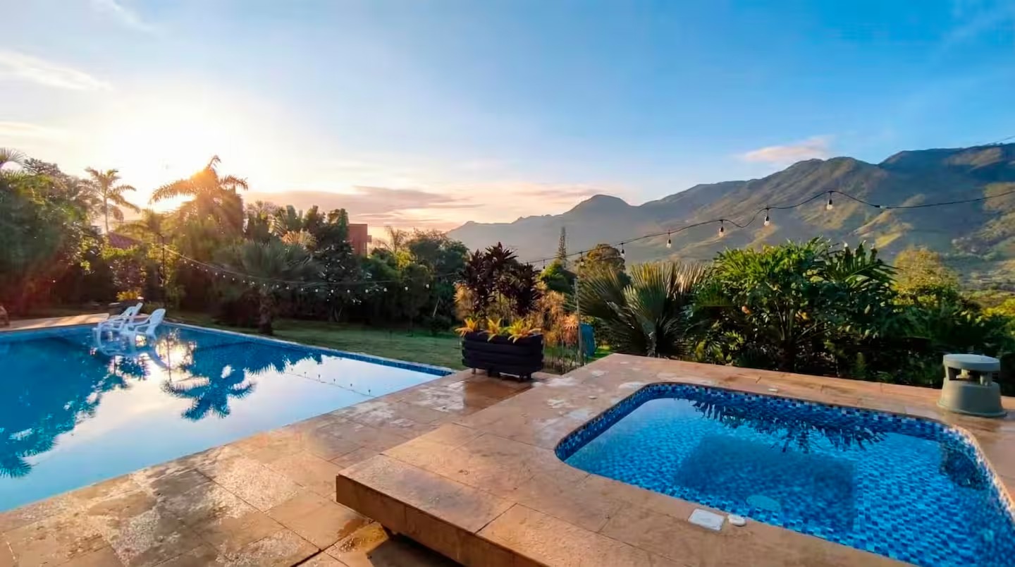 Infinity pool and jacuzzi at sunset with mountain views